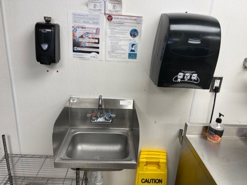 Hand sink with paper towel and soap dispensers